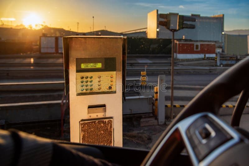 Digital terminal vid en industrivåg i solnedgång.