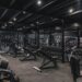 Ett modernt och välutrustat gym med hantlar och träningsbänkar.