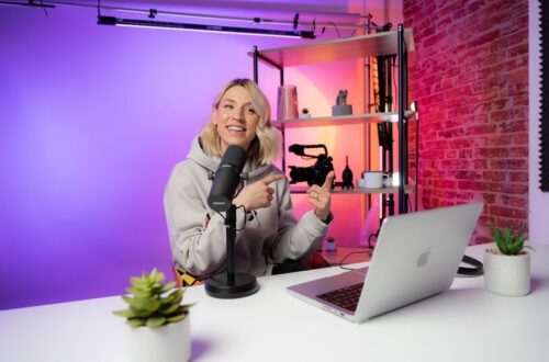 Innehållsskapare vid mikrofon och laptop i färgstark arbetsmiljö