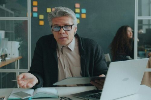 Affärsman presenterar material vid laptop i en modern arbetsmiljö