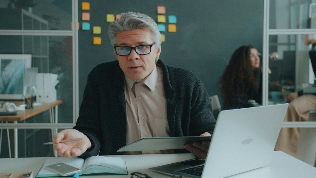 Affärsman presenterar material vid laptop i en modern arbetsmiljö